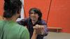 Fabrice is sitting on Alex's shoulders, looking at Matias and smiling